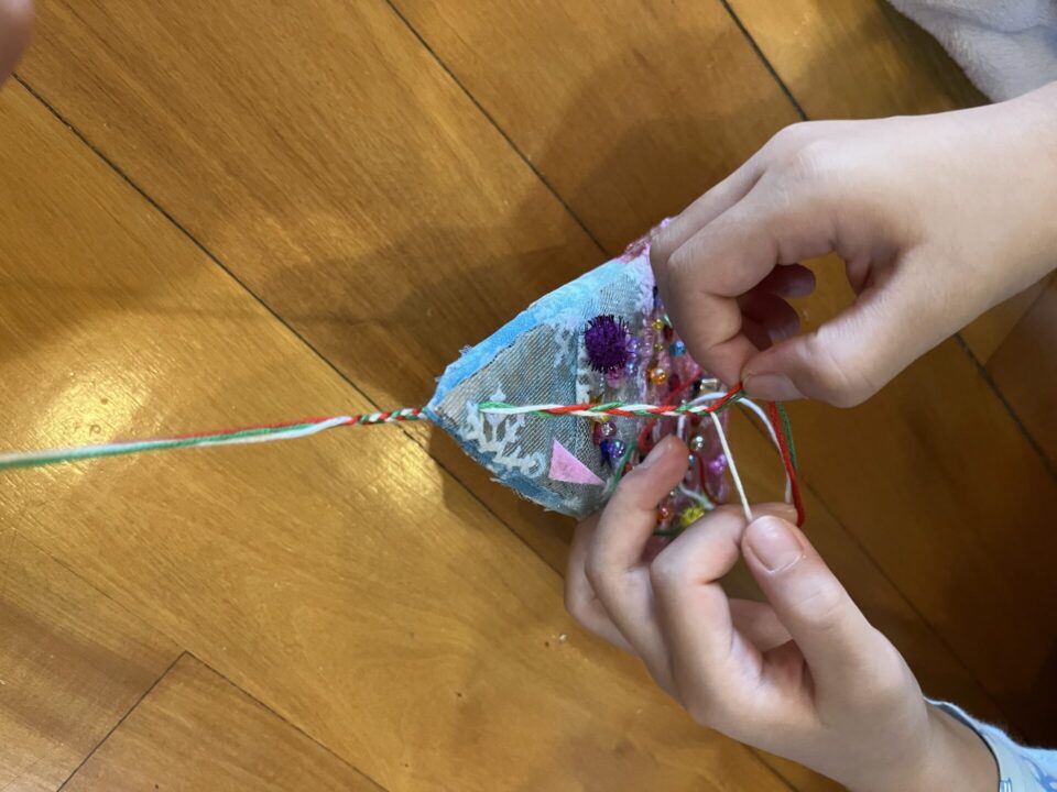 三女と向かい合って、三つ編みをします